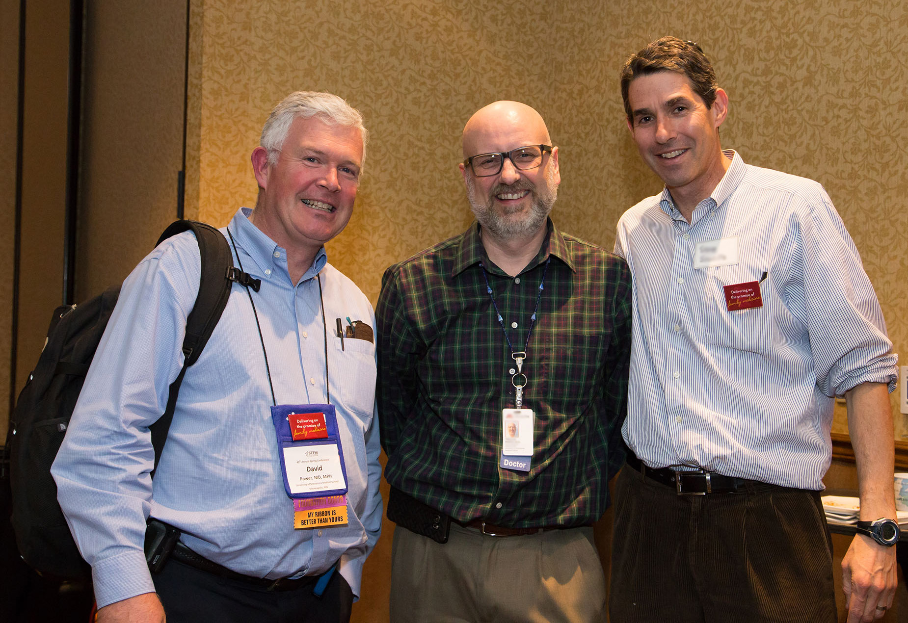 Dr. David Power with colleagues at a conference in a ballroom setting.