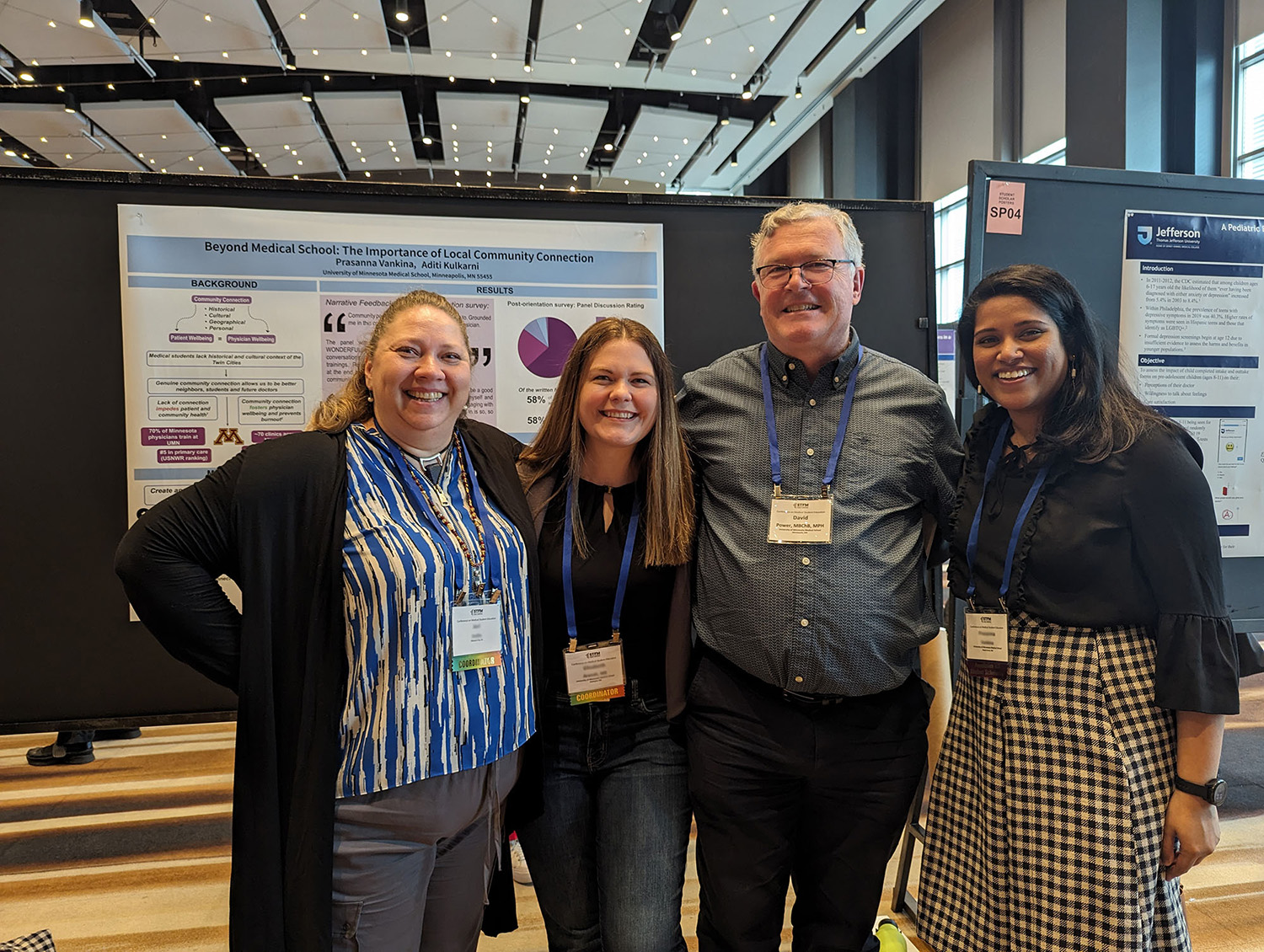 Dr. David Power with colleagues at a medical conference in a large ballroom.